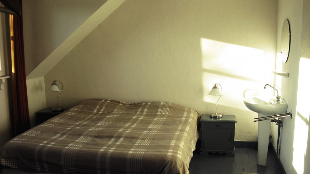 Chambre avec berceau, lavabo et vue sur le jardin