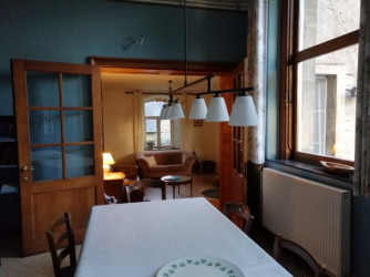 The living room with its open fireplace and wood burning stove is central between kitchen and dining room.